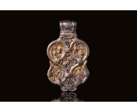 Ca. AD 800 - 1100. A silver-gilt pendant of symmetrical quadripartite form with rounded edges and a ribbed suspension loop. T