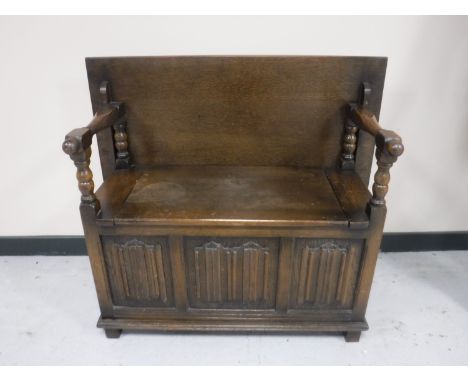 An oak linen fold monk's bench 