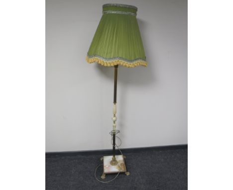 A brass and onyx standard lamp with shade on paw feet 