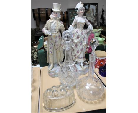 A tray of continental porcelain figures of a lady and gentleman together with two glass decanters, vintage glass jelly mould 