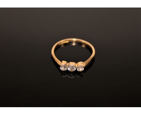 An 18ct gold three stone diamond ring, size M.