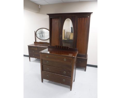 A three piece Victorian inlaid mahogany bedroom suite comprising of mirror door wardrobe, four drawer dressing chest and four
