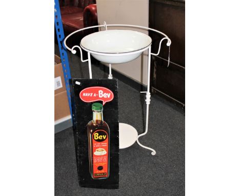 A metal framed wash basin and an enamel Bev advertising sign