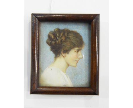 Early 20th century portrait miniature on ivory of a young girl in profile with her dark hair up, wearing a white top, signed 
