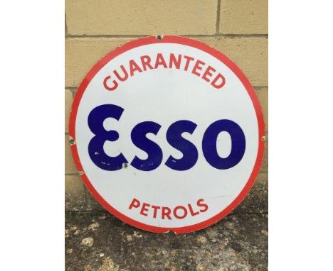 An Esso Guaranteed Petrols circular enamel sign, trimmed from a larger rectangular sign, 25 1/2" diameter.