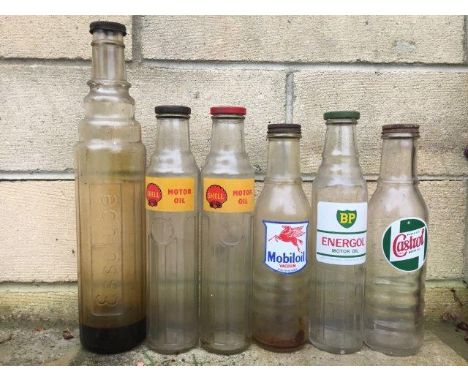 Six assorted glass oil bottles to include Shell, BP and Mobil.