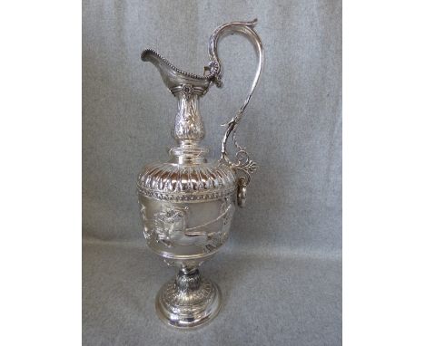 A Victorian neo-classical Ewer, by 'H. W. Crichton' London, 1868, the body embossed with chariots and female sprites, the lea