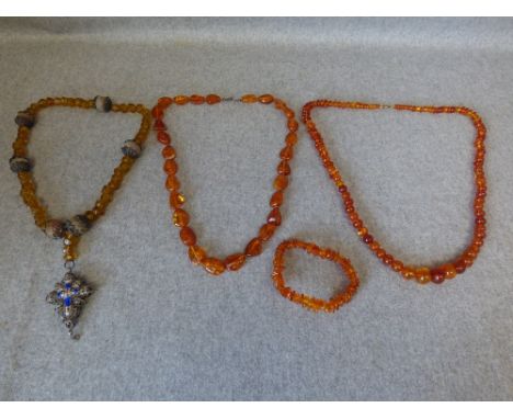 Row of amber beads, another row of amber beads and an elasticated amber bead bracelet, 68g gross; also a row of amber glass b