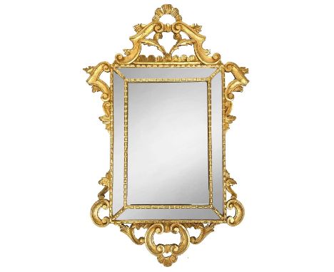 A late 19th early 20th century rococo style giltwood mirror carved with foliate scroll, 87cm x 51cm.The top pediment has been