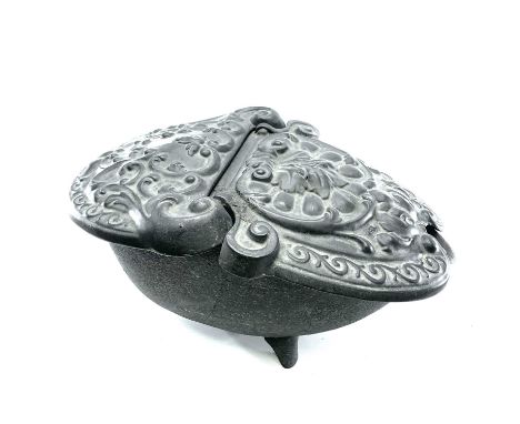 A Victorian cast iron oval coal box ornately cast with foliate scrolls on splayed bracket support, height 27.5cm length 52cm 