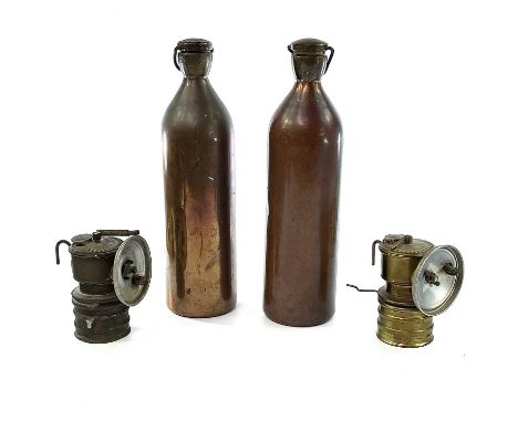 A Premier carbide brass miners lamp together with another Premier carbide lamp and two ICI copper black powder flasks.