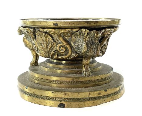 A 19th century bronze tazza with winged lion monopodia supports on a stepped circular turned base with applied leaf and scrol