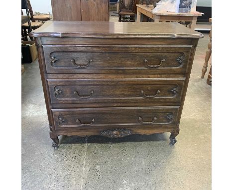 A French provincial oak commode, mid 20th century, fitted three long drawers, on scroll feet, height 85.5cm, width 101cm, dep