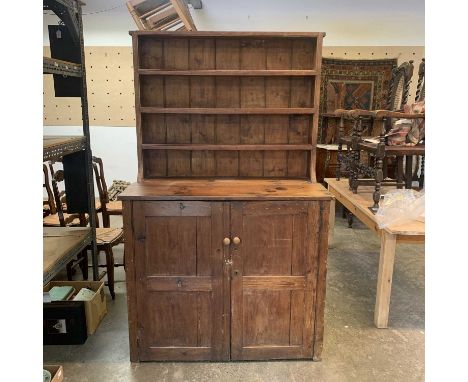 A rustic pine dresser, the raised back fitted three shelves above two panel cupboard doors, height 193cm, width 119cm, depth 