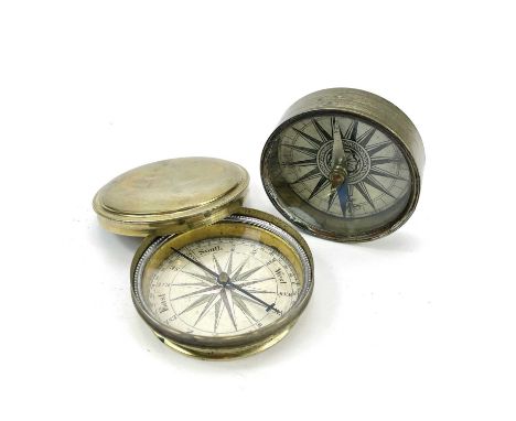 An early 19th century brass compass with a printed card dial and hardstone bearing, diameter 6.5cm together with another 19th
