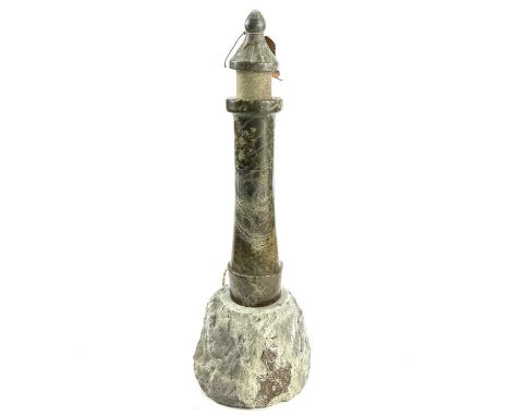 A Cornish serpentine turned and polished lighthouse lamp on a rocky base combined height 44cm.Glass canopy missing, needs rew