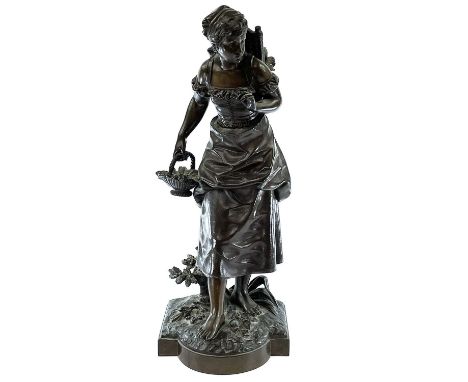 A bronze figure of a bare-foot farm girl, circa 1900, carrying a flower basket in her hand and with vegetables in a rattan ba