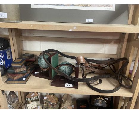 A pair of globe bookends together with wooden faux book bookends and a leather bridle