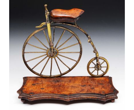 A MODEL of a 'Penny Farthing' originally a desk stand, now with ink pots missing on a serpentine base, circa 1900, 23cm wide