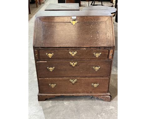 An 18th Century oak bureau with fitted interior over three drawers on bracket feet. 30½" wide.