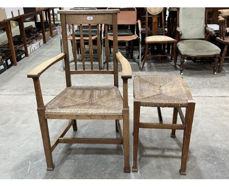 An Arts and Crafts oak stick back armchair with rush seat and a similar stool.