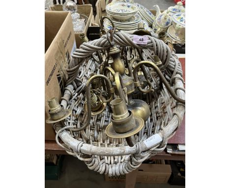 Two brass chandeliers, a wall light and a wicker basket.