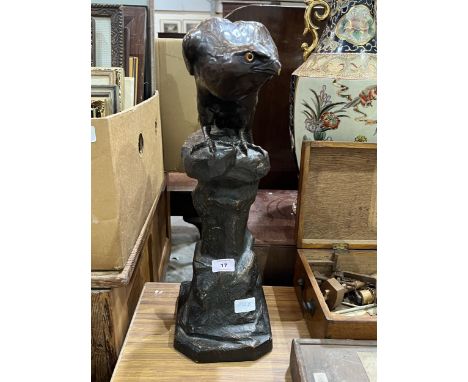 A ceramic figure of an eagle on a rock, bronze glazed with glass eyes. 20" high. Repair to rim.