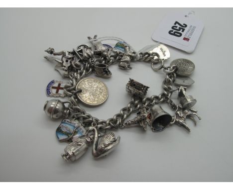 A Curb Link Charm Bracelet, suspending numerous assorted novelty charm pendants, including coins, enamel souvenir shields, we