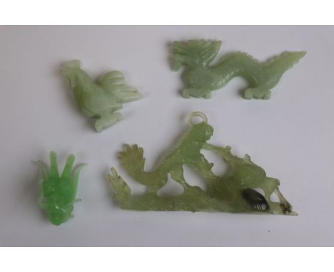 Jade type carved dragon, jade type carved rooster, soapstone carved mythical figure and a glass figure head 