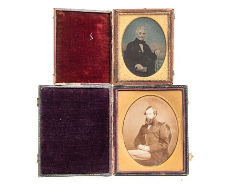 A mid 19th century hand tinted 1/4 plate ambrotype portrait of a  gentleman:, photographer unknown, seated beside a table wit