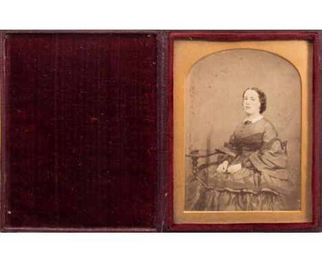 J C Barrable, London an ambrotype portrait of a seated woman:, hand tinted to face, lace collar and jewellery, in an arched g