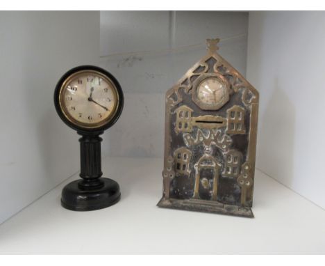 A late 19th Century money box in the form of a bank, brass and black metal, together with a fluted pillar ebony desk clock (2
