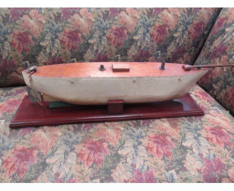 A vintage hand crafted wooden pond boat hull on stand, 14cm tall