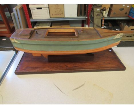 A vintage hand crafted wooden pond boat hull on stand, 22cm tall