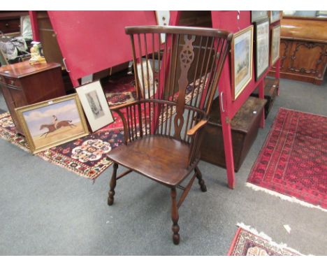 An elm seat high-back Thames Valley Windsor armchair with stick-back and wheel central splat on turned legs joined by an "H" 