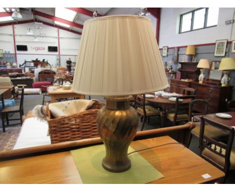 A brass table lamp with pleated shade