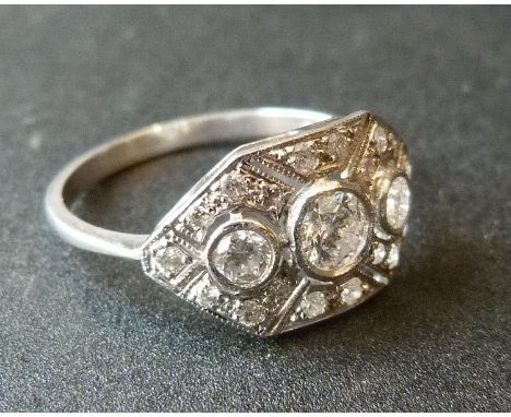 An 18ct. White Gold Art Deco Style Diamond Ring with three diamonds surrounded by smaller diamonds within a pierced setting
