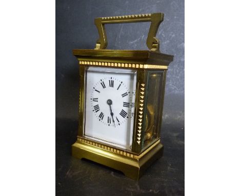 A French Brass Cased Carriage Clock, the enamel dial with Roman numerals and lever escapement and carrying handle