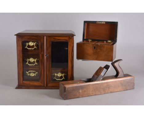 An early 20th Century walnut smoker's cabinet, bevelled glazed panel doors, two short drawers one long, ornate brass handles,