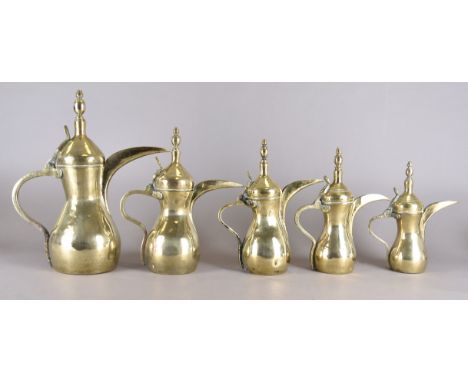 A set of five vintage graduated Middle-Eastern brass coffee pots, smallest 26.5 cm high, largest 40.5 cm high. Together with 