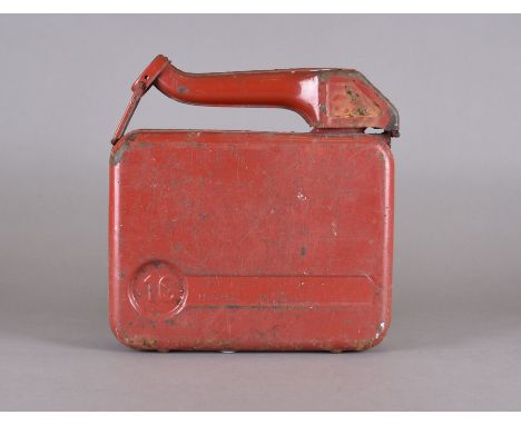 A vintage red painted petrol canister together with two leather suitcases, one missing handle 