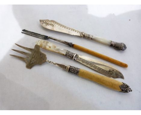 Two Victorian silver plated fish knives with mother-of-pearl hafts together with a pickle fork and a meat fork with silver co