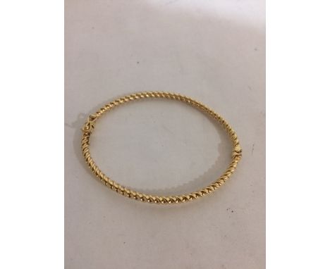 A 14ct twist design hinged bangle. 4.5g