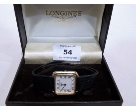 A Longines lady's wristwatch, the two colour tank case with enamel dial and Roman numerals, the crown with a blue cabochon. M