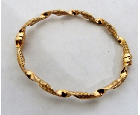 A 9ct ribbon twist hinged bangle. 6.1g