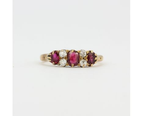 An 18ct yellow gold ring set oval cut rubies and rose cut diamonds, (K).