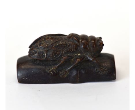 A carved fruitwood Netsuke of a cicada on bamboo with inset mother of pearl signature panel, L. 6cm.