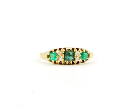 A hallmarked 18ct yellow gold ring set with fancy cut emeralds and diamonds, (K).