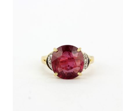 A hallmarked 18ct yellow gold ring set with a large glass filled round cut ruby and diamonds, (N).