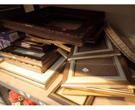 Shelf of assorted framed and glazed prints and pictures and empty picture frames large and small